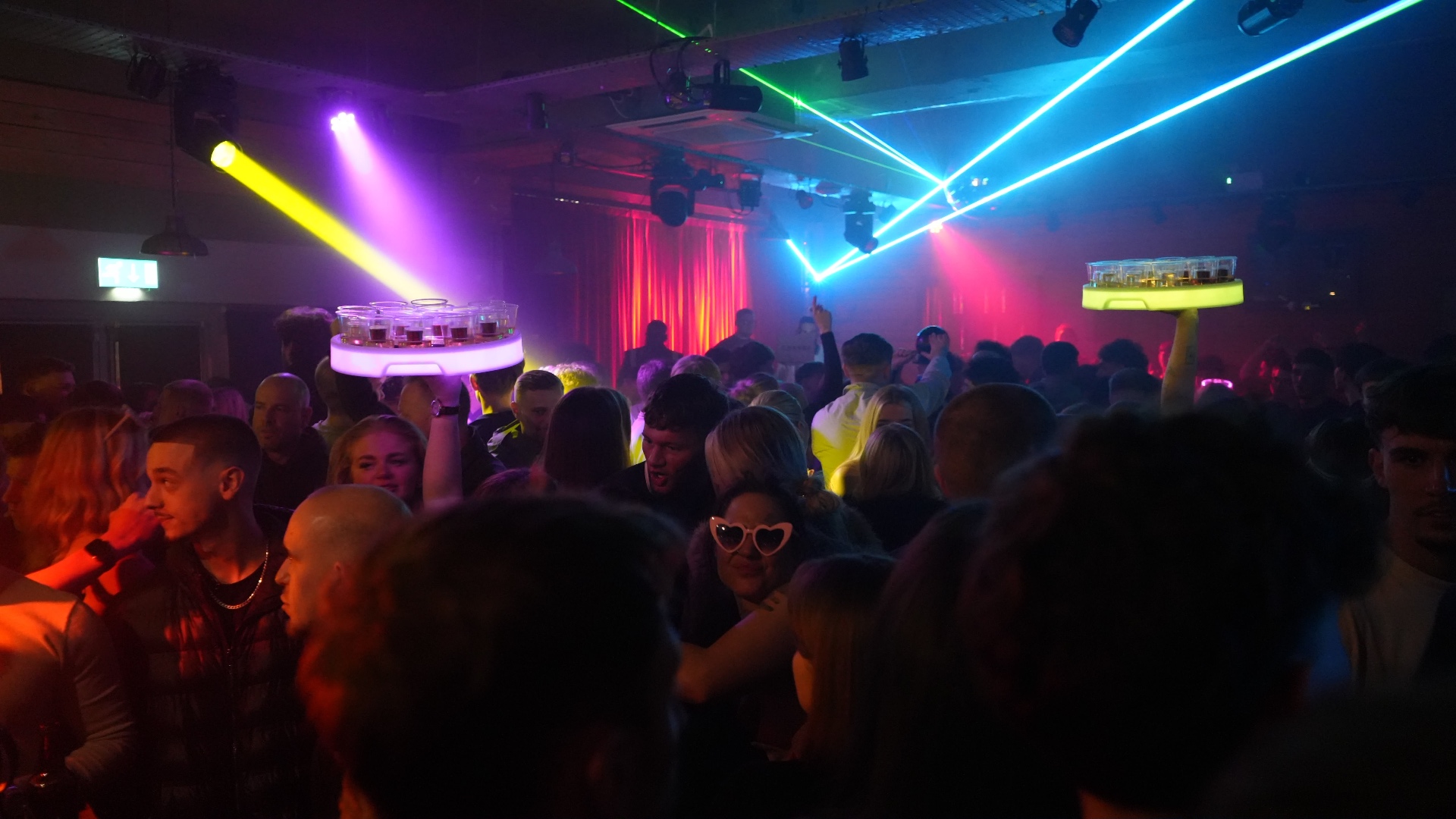Reign Promotions shot sellers working a packed nightclub with laser lights