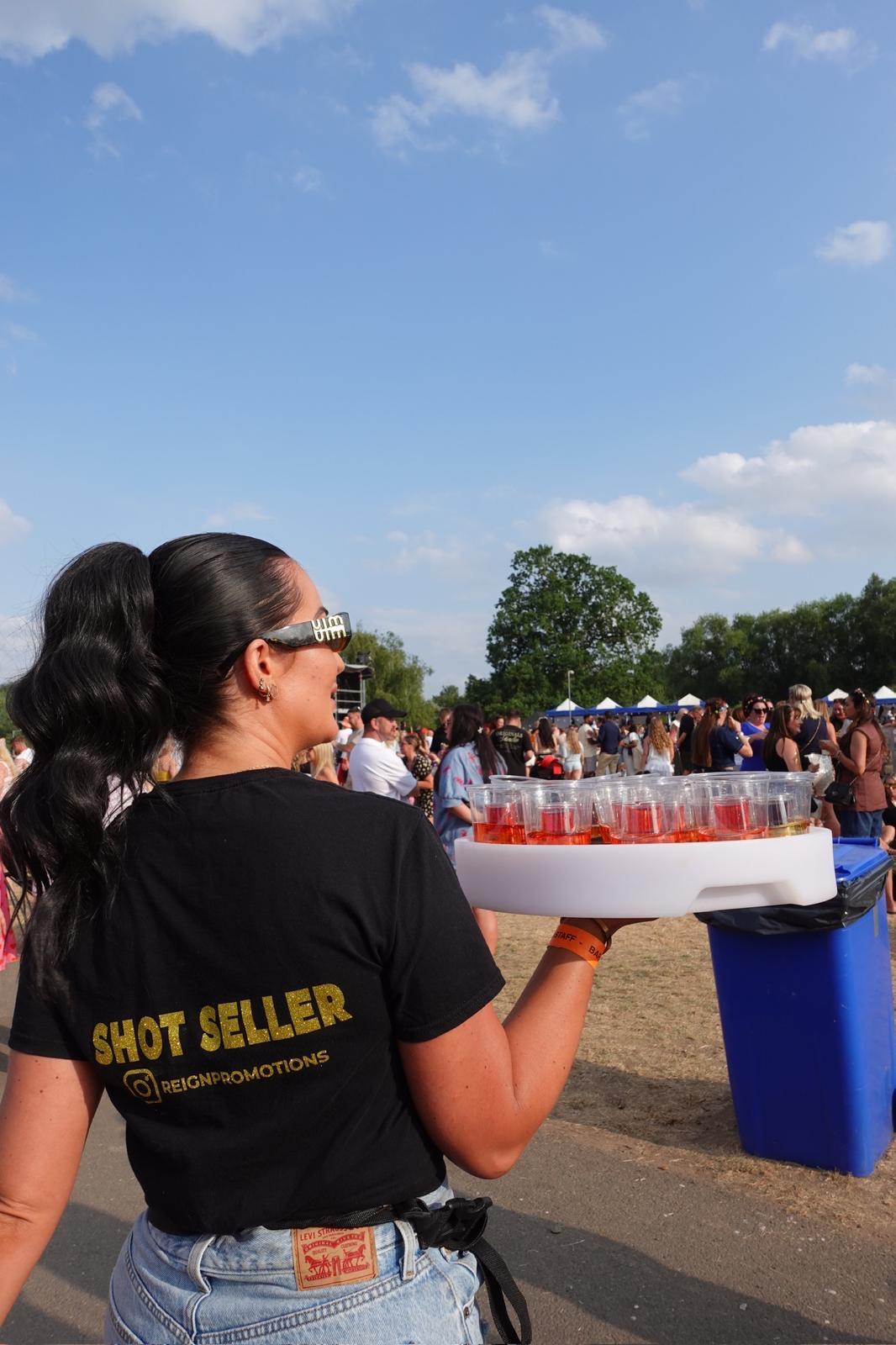 Reign shot seller with tray from behind at a festival crowd