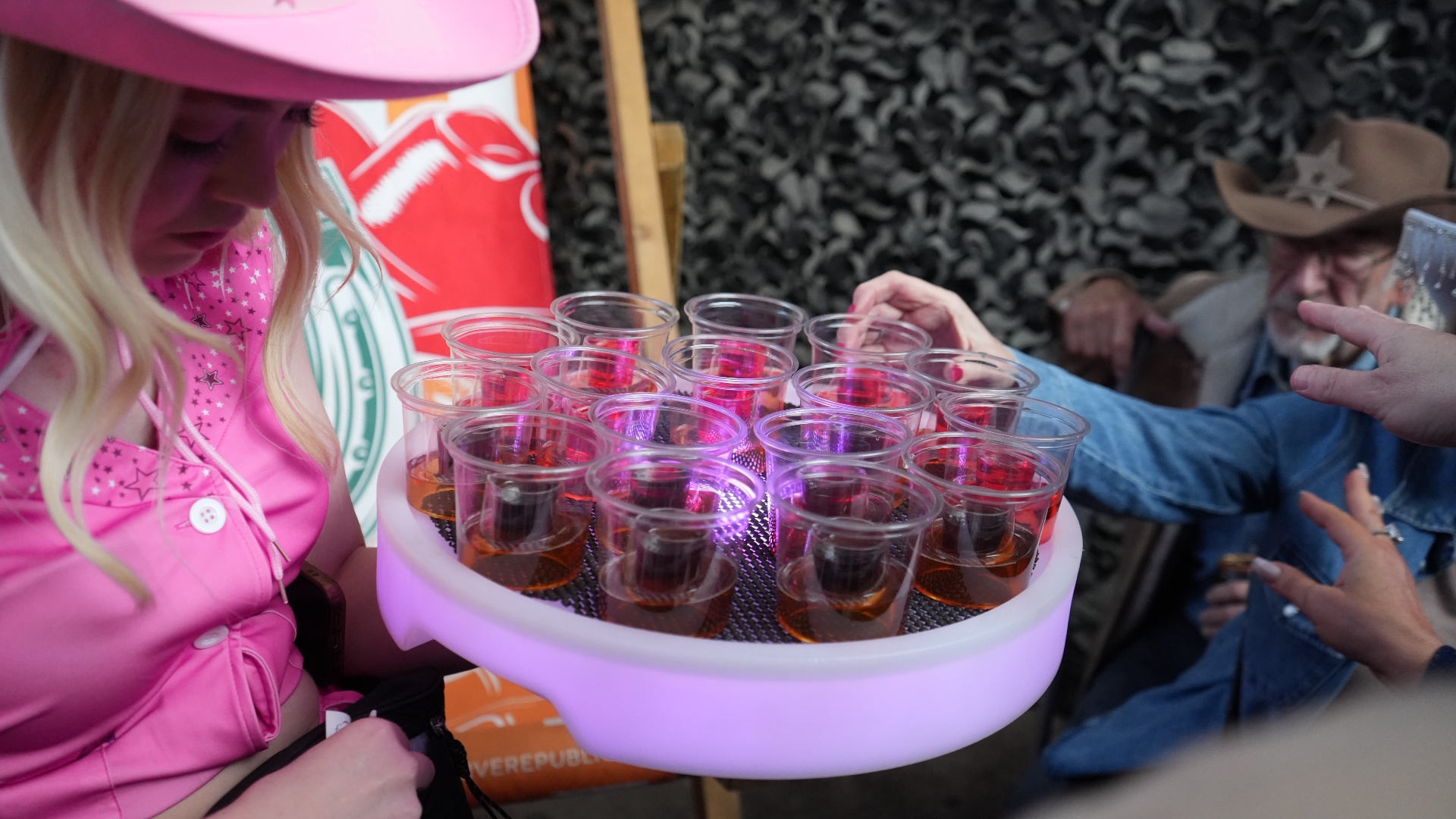 Reign shot seller in cowgirl outfit at a festival stand