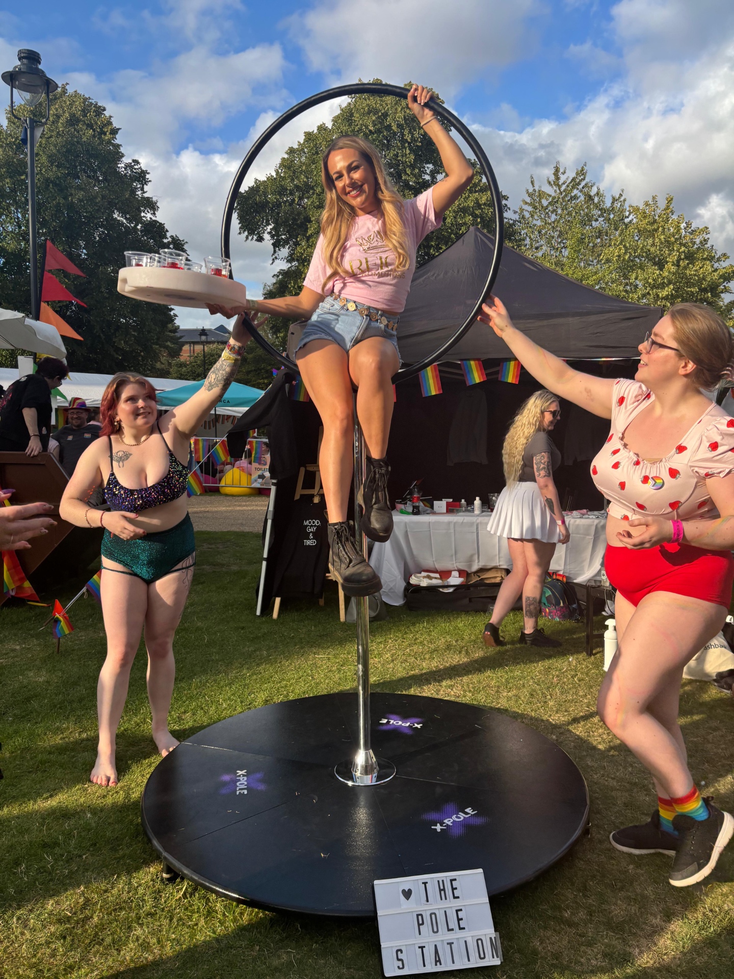 Reign performer on aerial hoop serving shots at Pride