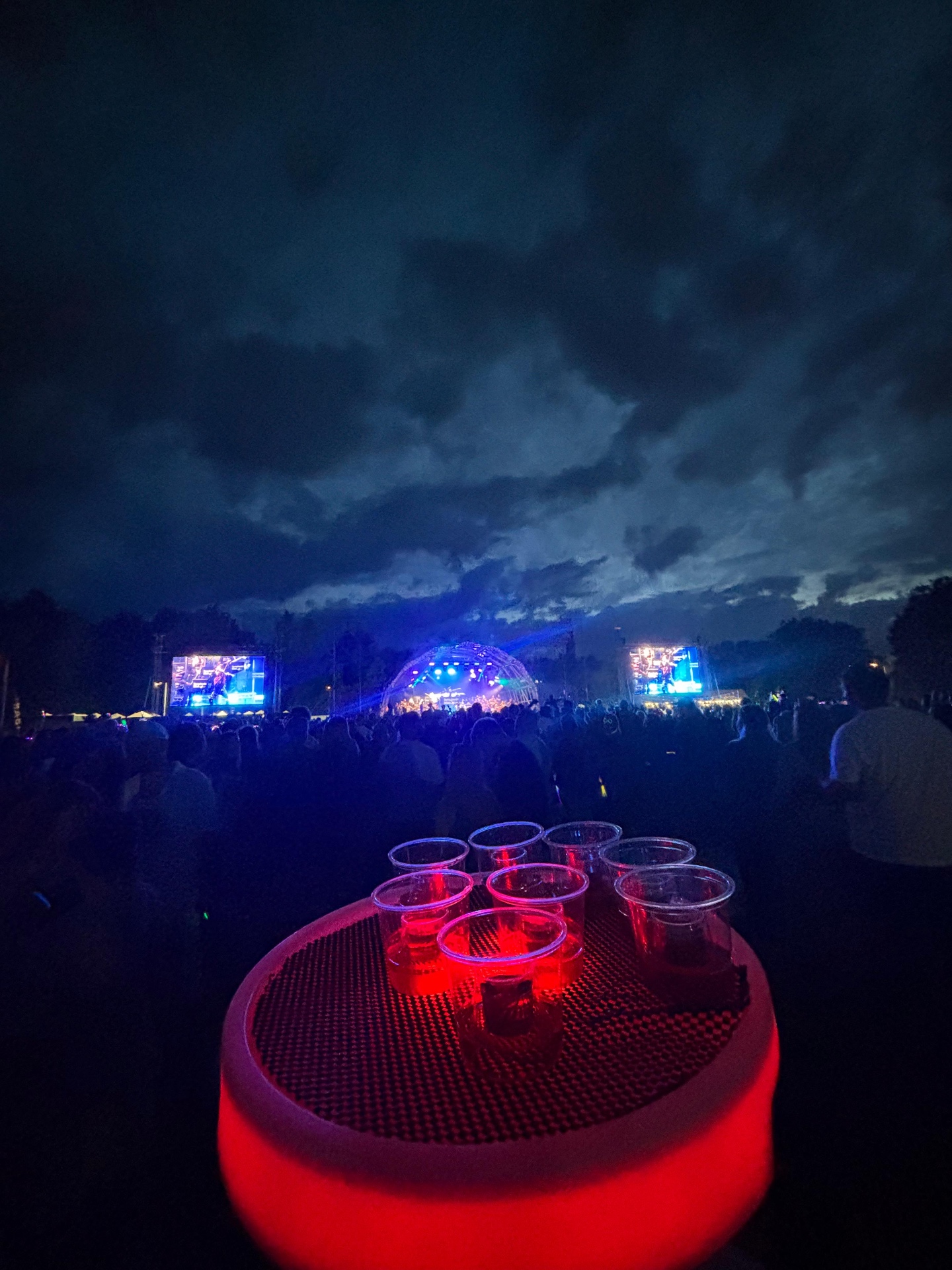 Reign shot tray at a festival main stage at dusk