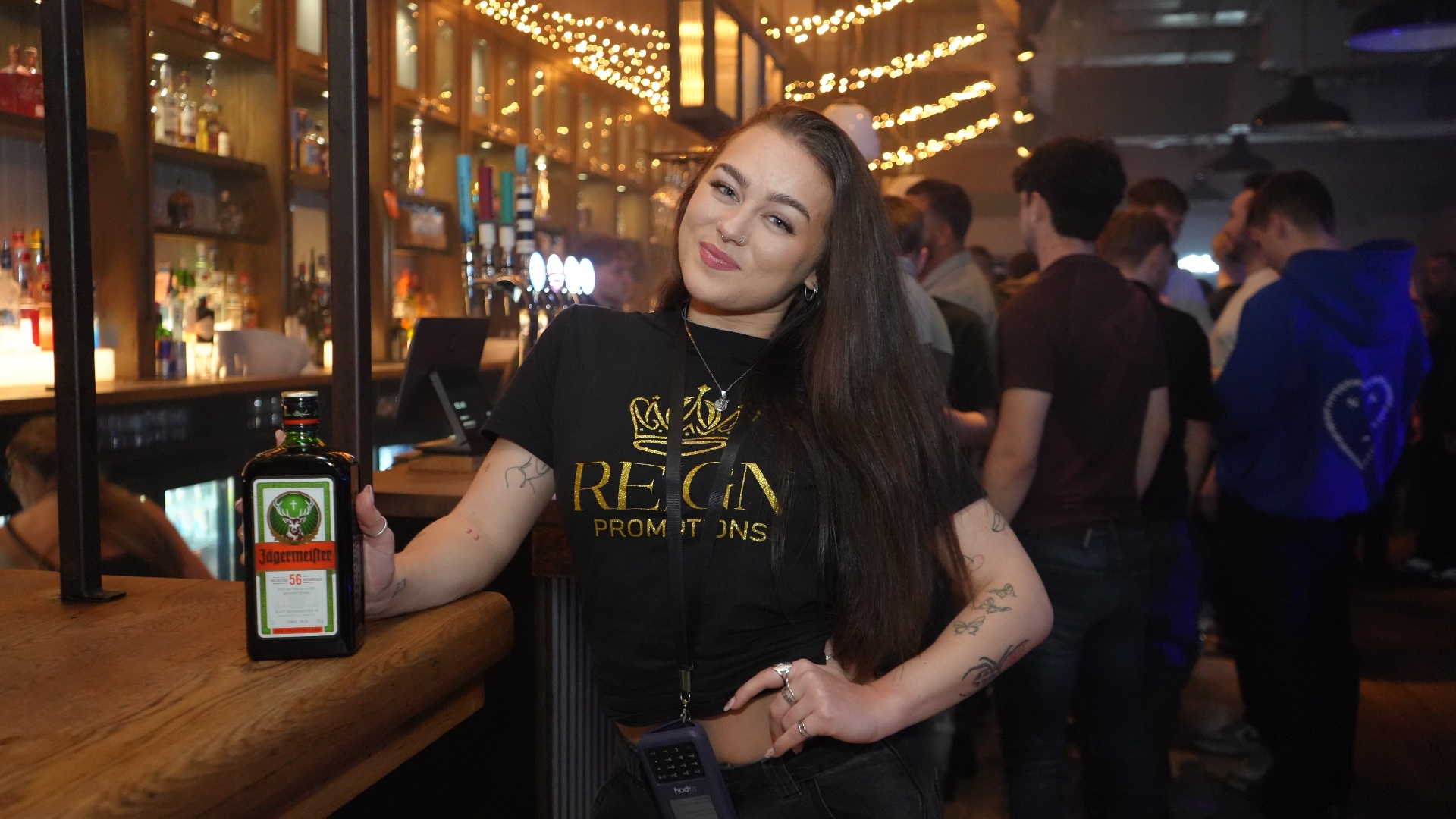 Reign shot seller with a Jägermeister bottle under fairy lights